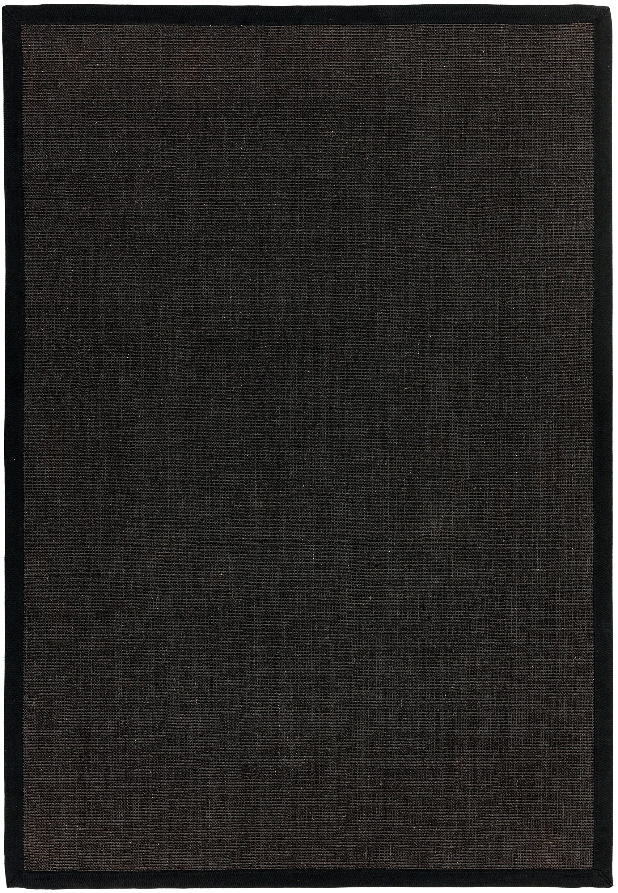 A black flatweave rug, light enough to slip without a grip underlay