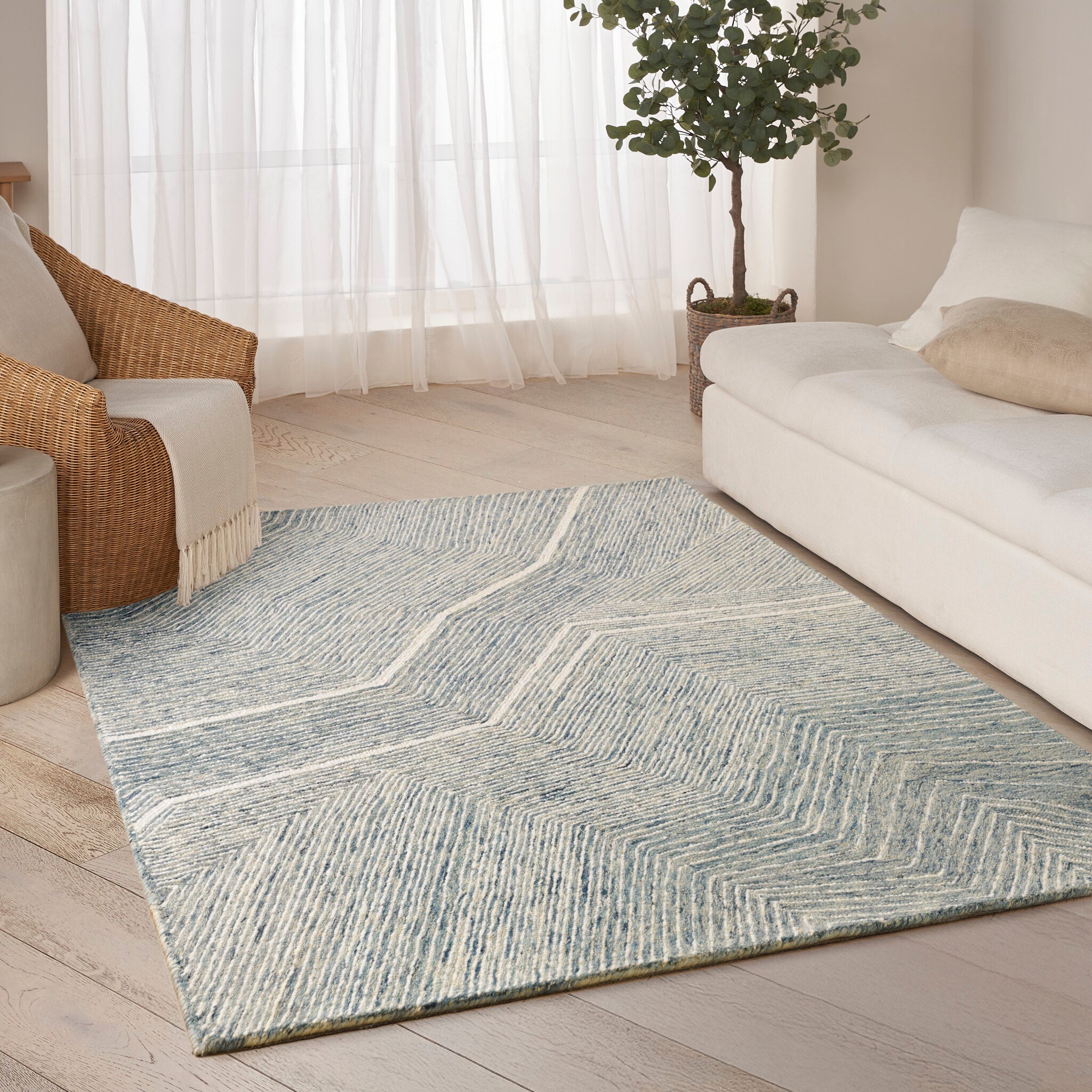 An ivory and blue designer rug in a living room setting