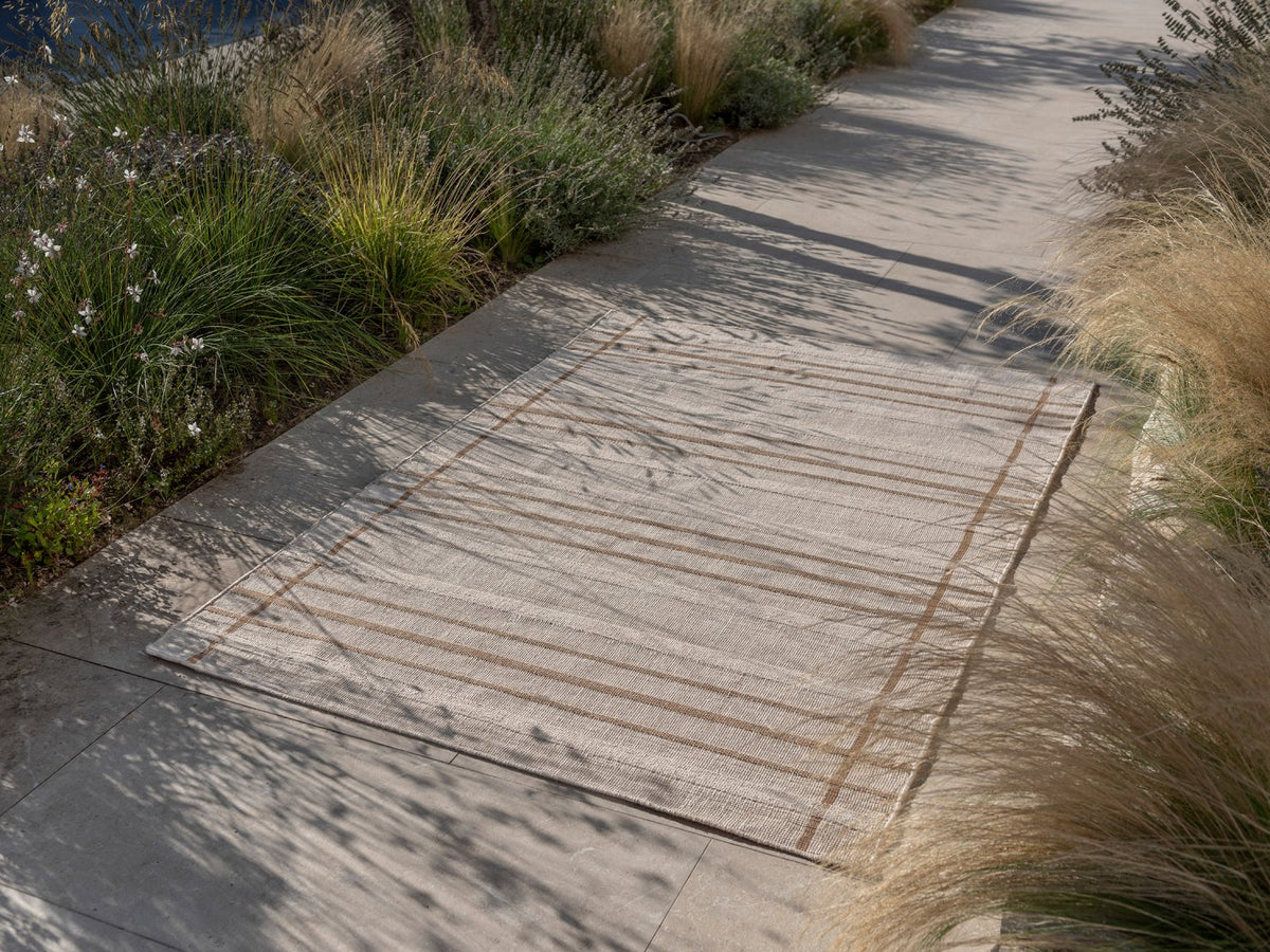 Zona Line Sesame outdoor rug on a path