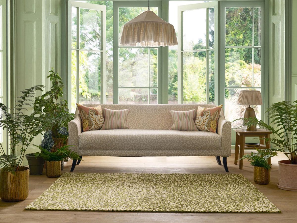 Sanderson Truffle Olive outdoor rug styled in a room setting