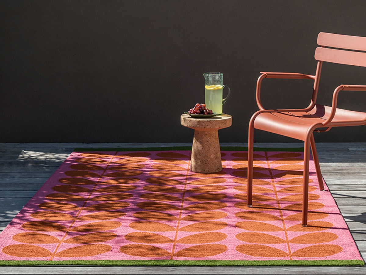 Orla Kiely Solid Stem Paprika outdoor rug on a terrace