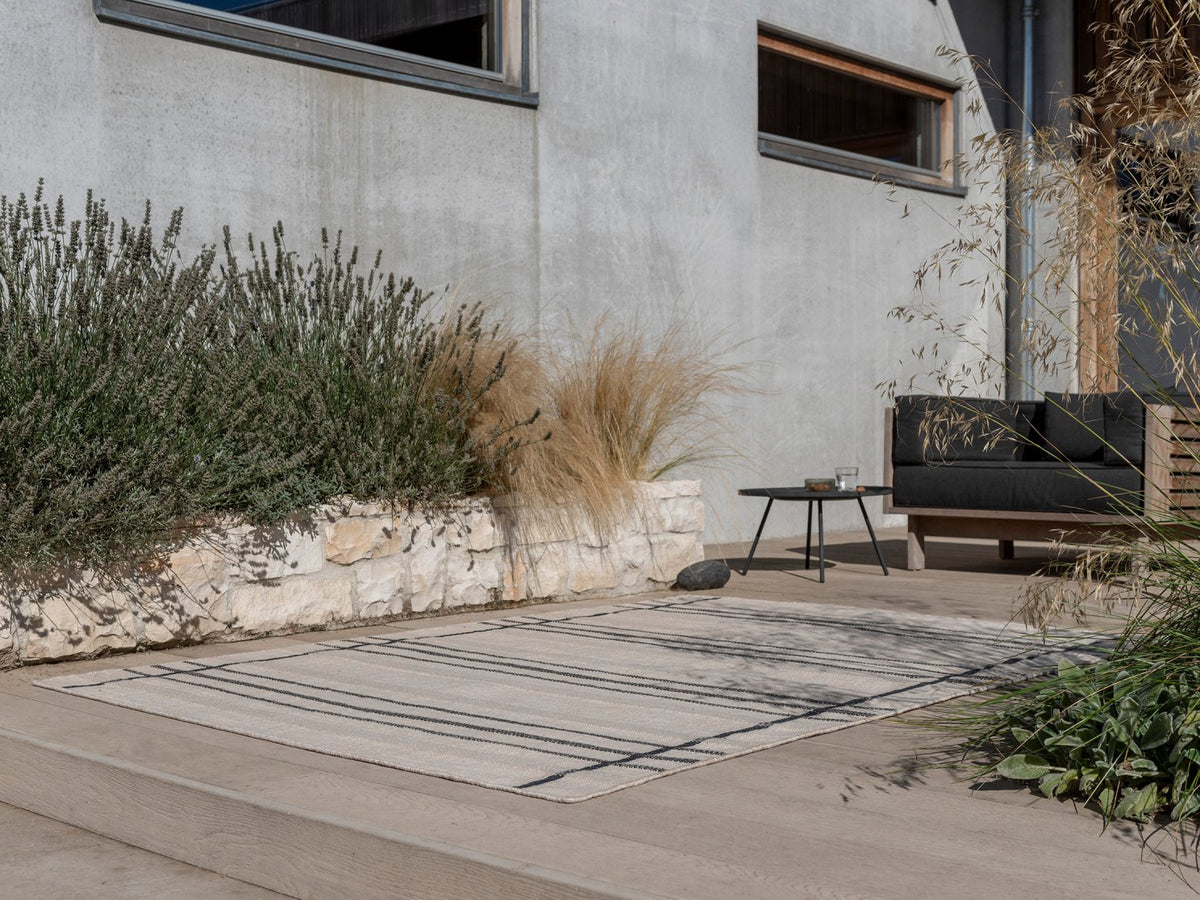 Zona Line Charcoal outdoor rug on a terrace