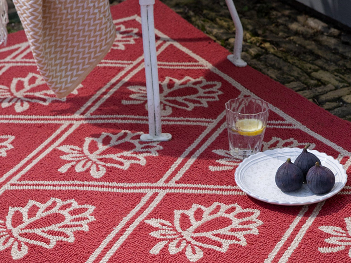 Laura Ashley Porchester Poppy Red outdoor rug on a terrace