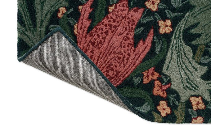 Morris & Co Lent Lily Indigo Madder rug corner turned to show the backing