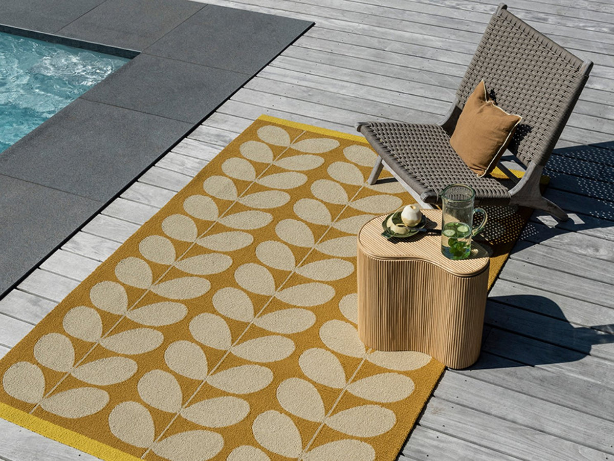 Orla Kiely Solid Stem Sunflower outdoor rug on a terrace