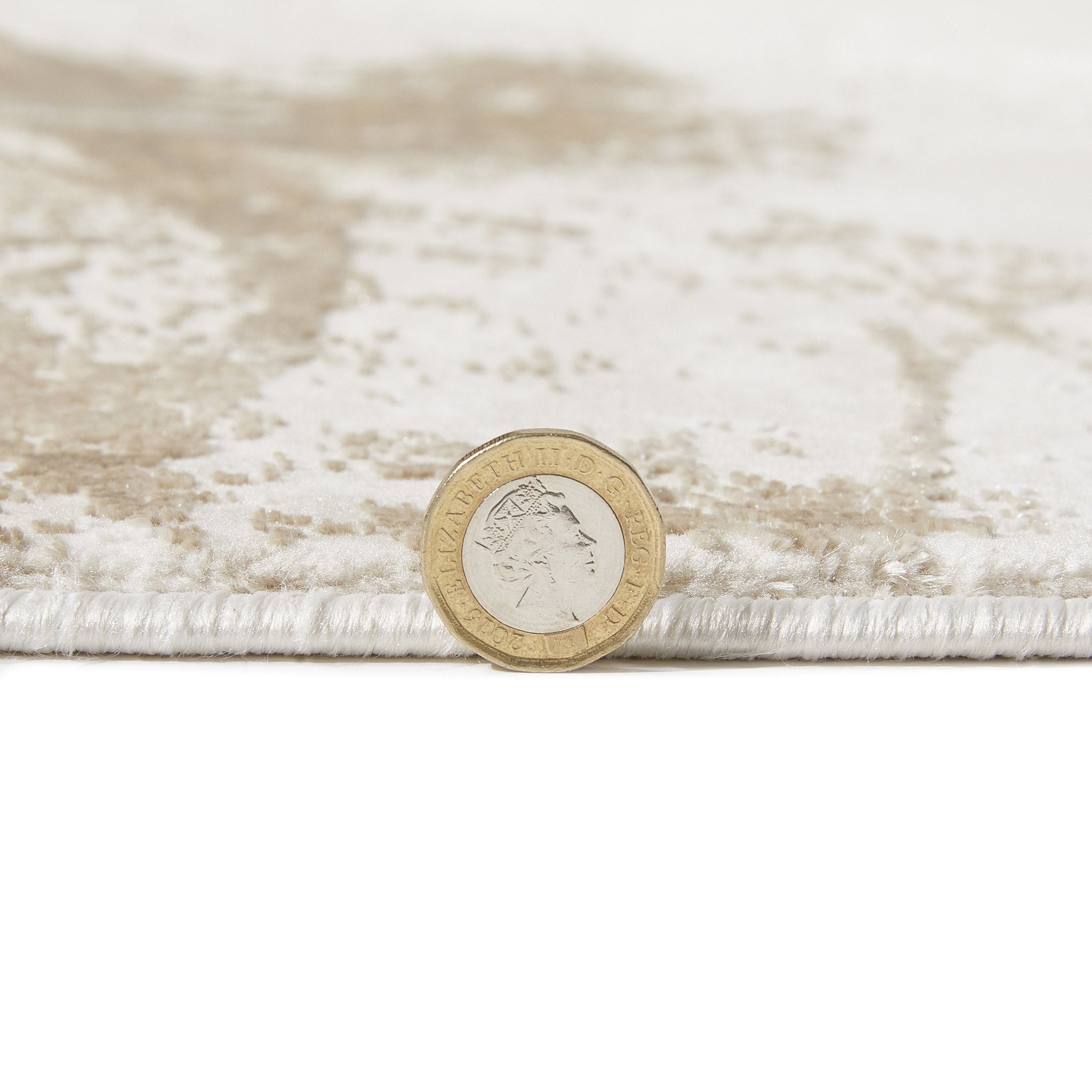 Santa Monica Beige rug pile height shown against a coin for scale