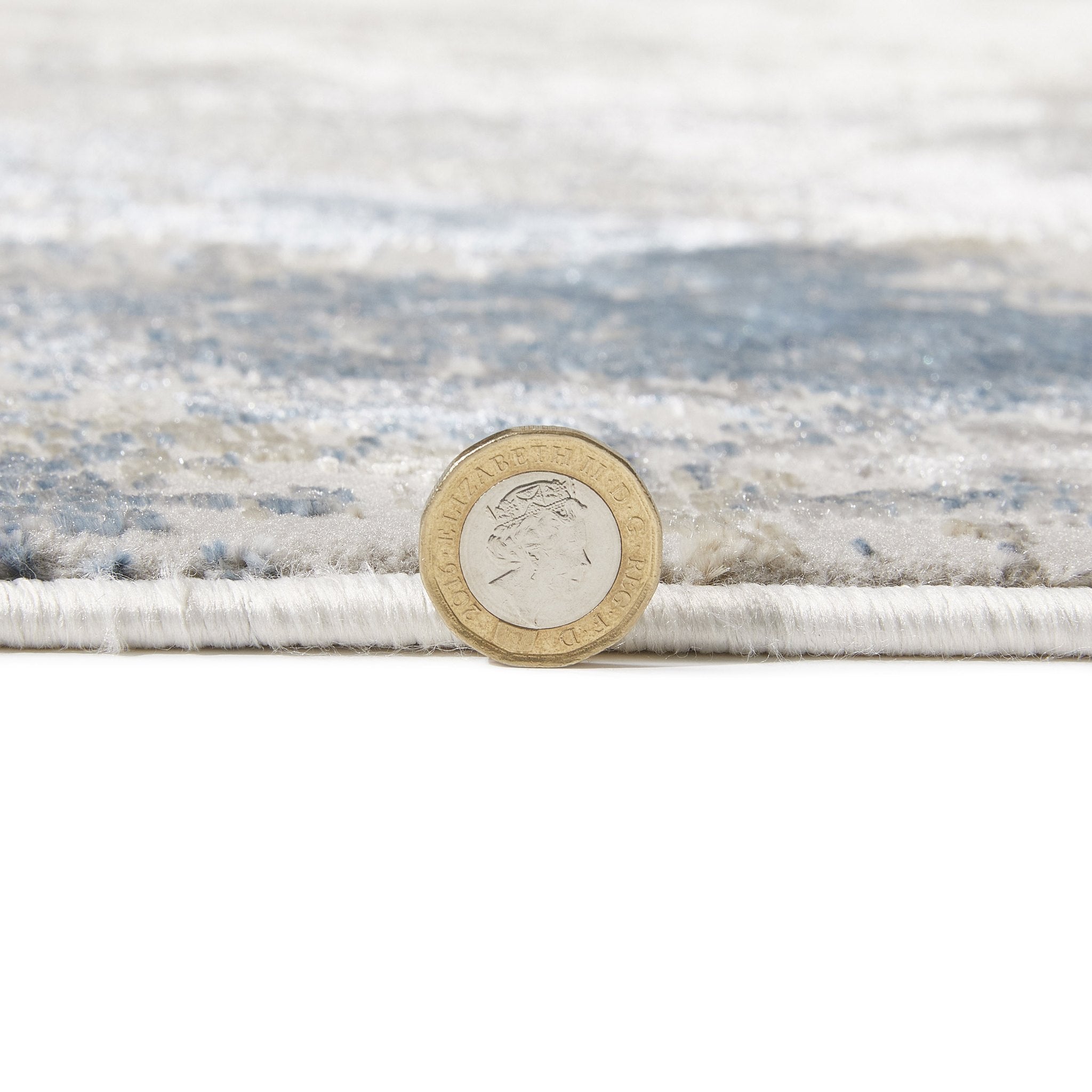 Santa Monica Grey Blue rug pile height shown against a coin for scale
