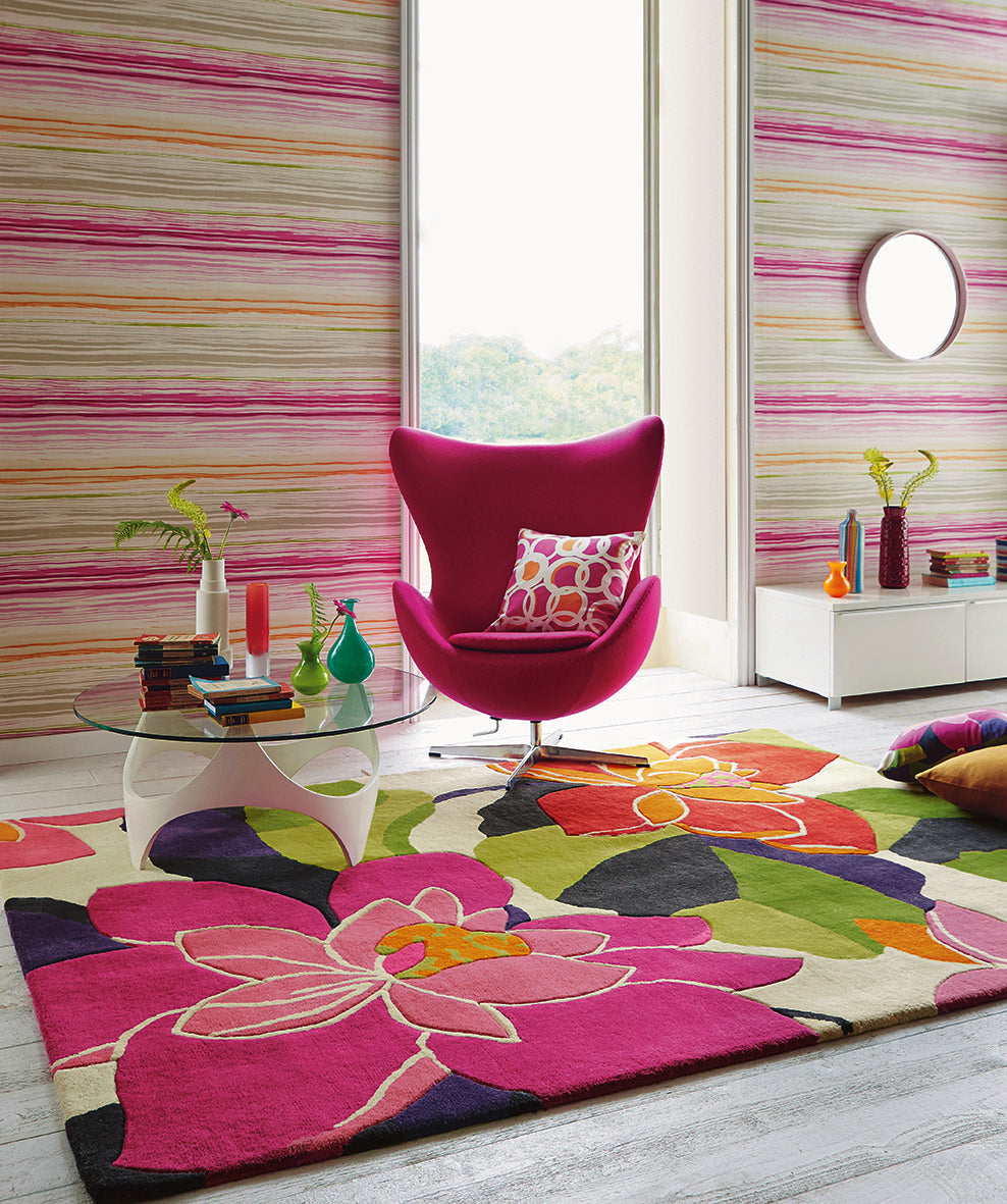 A bold fuchsia patterned designer rug in a room setting