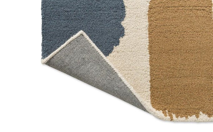 Scion Composition Papaya rug corner turned to show the backing